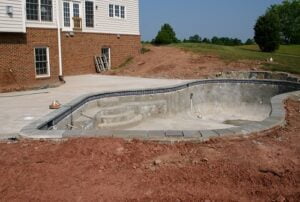 Creating a concrete swimming pool in residential backyard